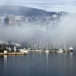 Segelboote im Nebel vor Stadtpanorama
